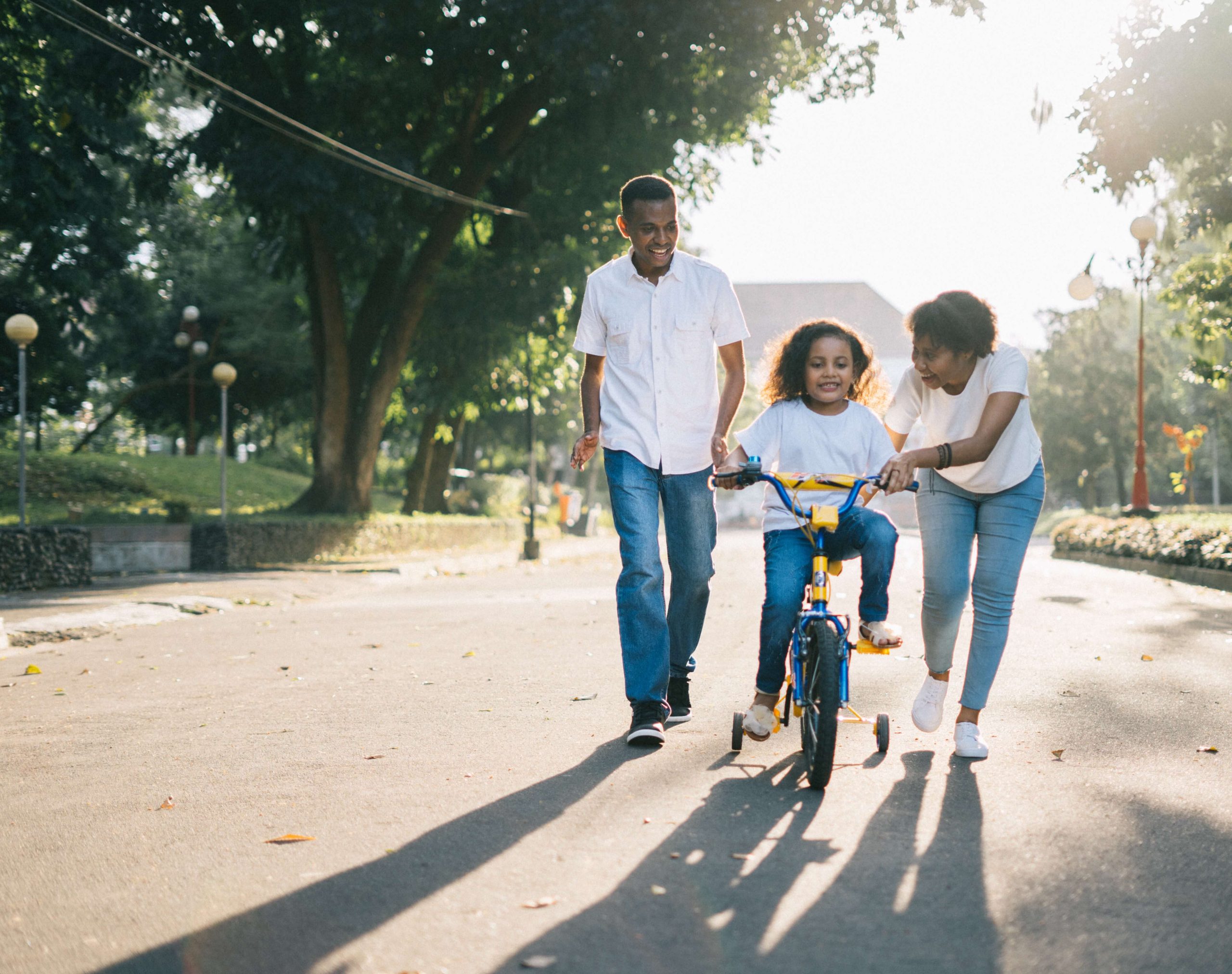 Parents teaching their child on how to ride a bike in a mobile home park community
